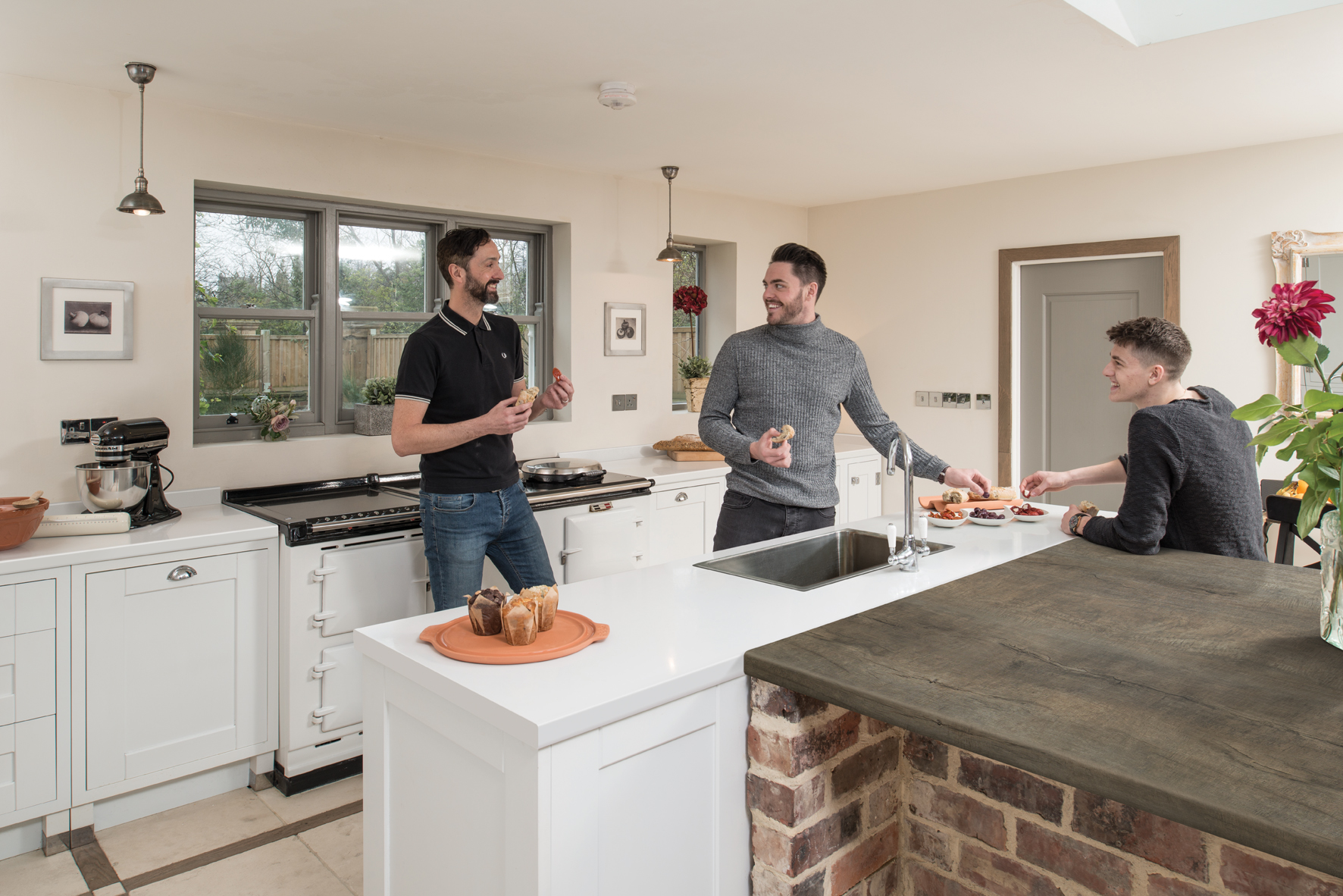 Male friends eating and drinking in modern kitchen fitted with Axiom Thai Beamwood Worktop 